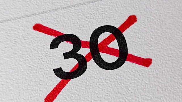 Crossing out number 30 on calendar with red marker. Concept of cancellation or completion