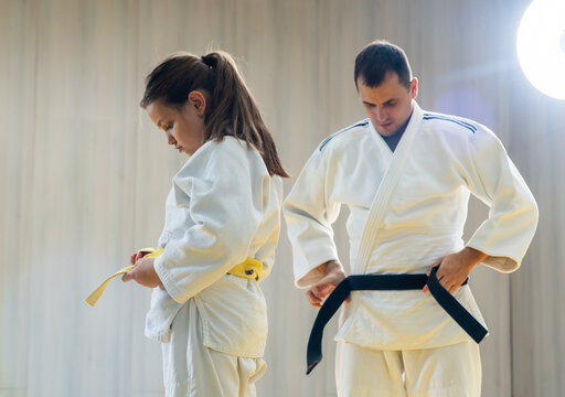 Father and daughter preparing for martial arts practice together
