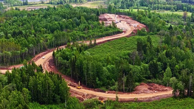 Aerial view of heavy machinery working on forest road construction project.
