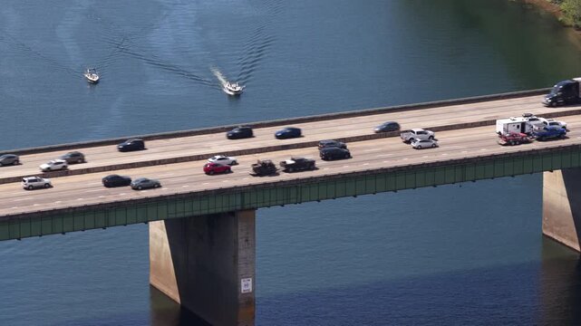 Aerial close up of multilane Interstate 5 bridge crossing Willamette River in Oregon with heavy traffic and boats on river