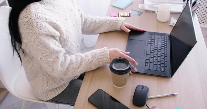 Computer job. Workspace routine. Unrecognizable business woman typing on laptop at desk with smartphone sticky notes at workplace.