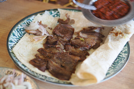 Savoring delicious grilled meat on a warm tortilla. this is also know as Cag Kebap in turkey