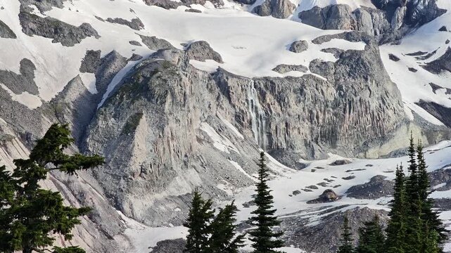 Snowmelt waterfall cascading down rocky mountain cliff in Washington
