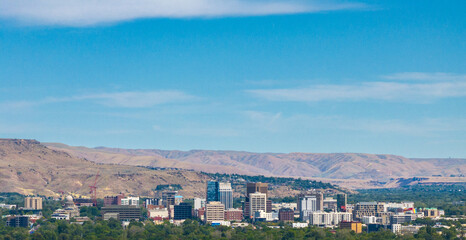 Obraz premium Panoramic view of a city with skyscrapers under a bright blue sky
