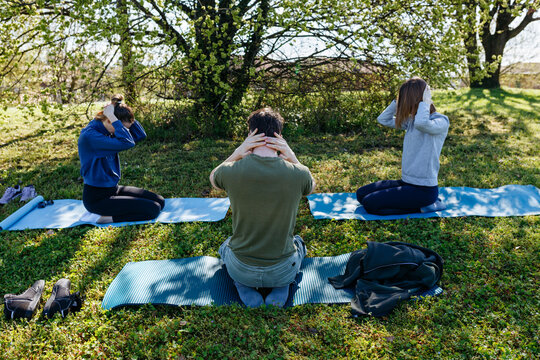 Group of friends stretching exercise outdoors in a park
