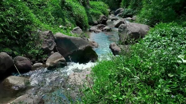 A river flows steadily through a rocky landscape, water curling around stones and forming small eddies along the edges. The natural rhythm of the current offers a simple way to release tension .