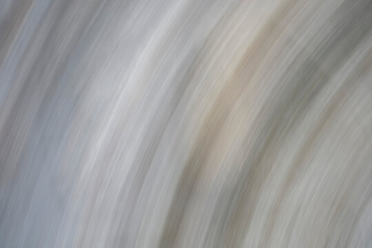 Abstract ICM (Intentional Camera Movement) photography featuring a fluid flow of cool grey, pearl white, and taupe tones. Smooth motion blur creates a minimalist, serene energy.