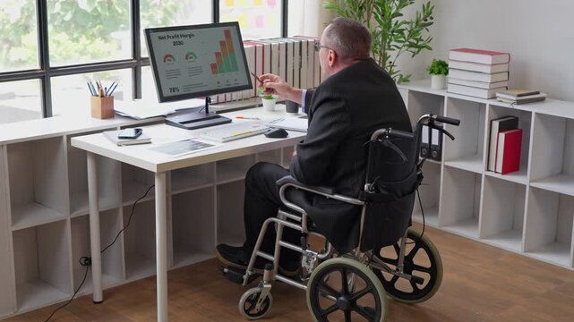 Disabled senior businessman working on computer in office