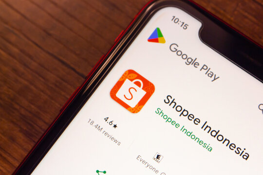 Mexico City, MEXICO - Jul 7 2026 : Angled close-up of a smartphone displaying the Shopee Indonesia listing on the Google Play store, on a wooden surface.