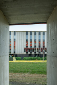 Hasselt, Belgium. Modern university building framed by exposed concrete passage on academic campus