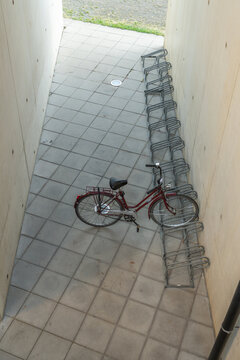 Hasselt, Belgium. Bicycle parked in minimalist bike rack beneath modern university building