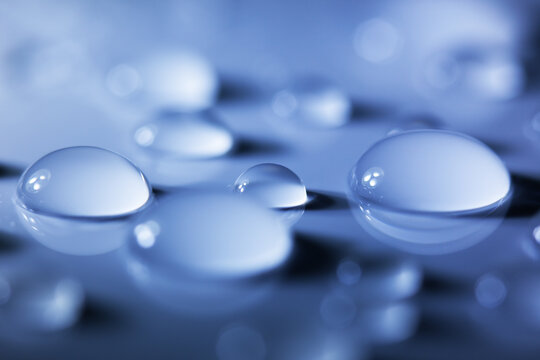 Macro of Clear Water Droplets on Blue Background
