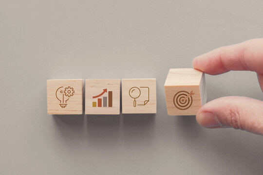 Hands holding wooden blocks with business icons, business strategy management, set goal and target, collaboration business concept 