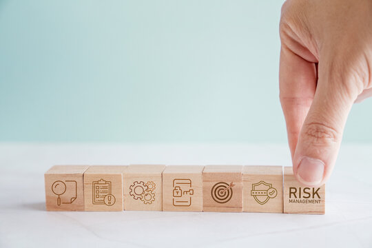 Hand holding wooden block with Risk management icons, business strategy concept
