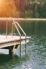 Fototapeta premium Clear alpine lake with wooden pier