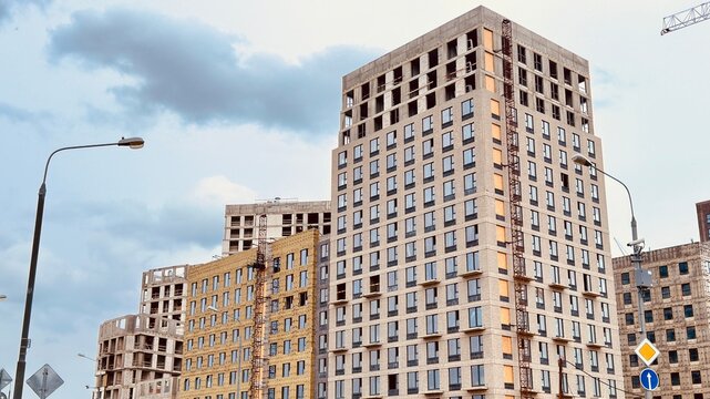 Construction process of Salaryevo Park residential complex by PIK group in Moscow. Contemporary high rise apartment buildings under development with unfinished facades and cloudy sky backdrop.