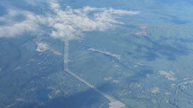 Aerial view of forested landscape with highway and clouds in Washington