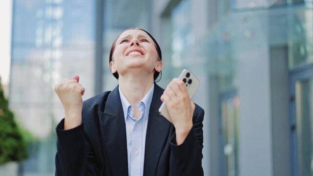 Businesswoman experiences shock and frustration reacting to distressing news on smartphone outdoors. Feelings of anger, sadness, and disappointment are evident in emotional display.