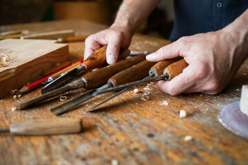 Carpenter hands with handmade wood carving tools set at workbench. Joinery, carpentry, wooden craftsmanship and handwork. © juliasudnitskaya
