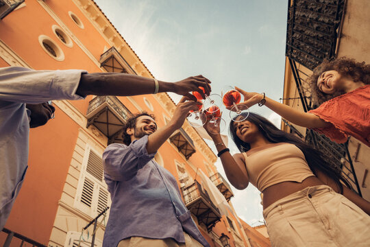 Friends toasting glasses of wine in historic Mediterranean street