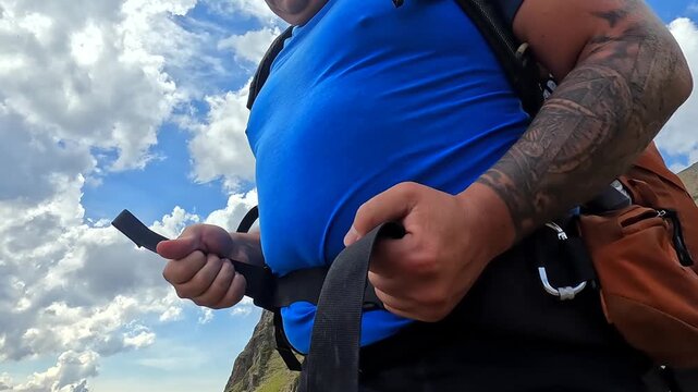 Backpacker fastening waist belt close-up in Georgia, adjusting hiking pack on mountain slope for trekking preparation, outdoor equipment, travel safety, load support, and expedition training footage