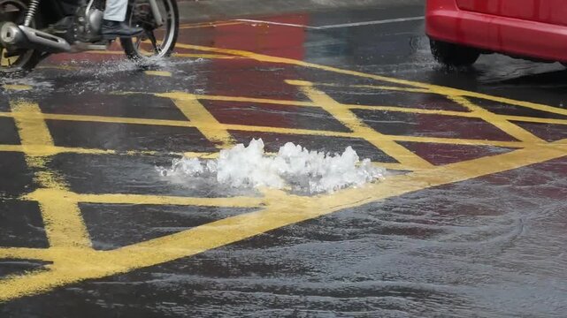 Water bursting out from manhole in the middle of the road