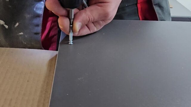 Screw fastening process on a metal sheet in a workshop