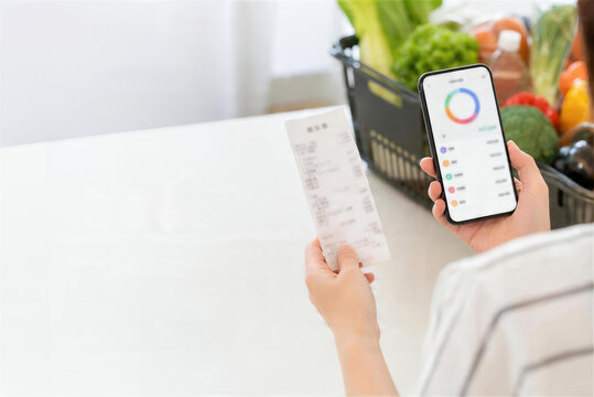 レシートとスマホ家計簿で食費を確認する日本人の手元