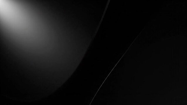 Abstract black background with a soft, bright light source in the top-left corner illuminating subtle curves and lines, creating a minimalist and modern aesthetic.