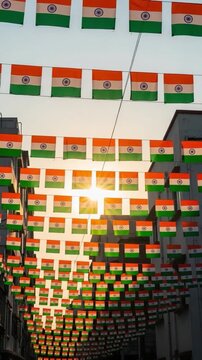 Rows of Indian National Flags Hanging Between Buildings Celebrating Independence Day with Sun Flare Background for Patriotic Concept