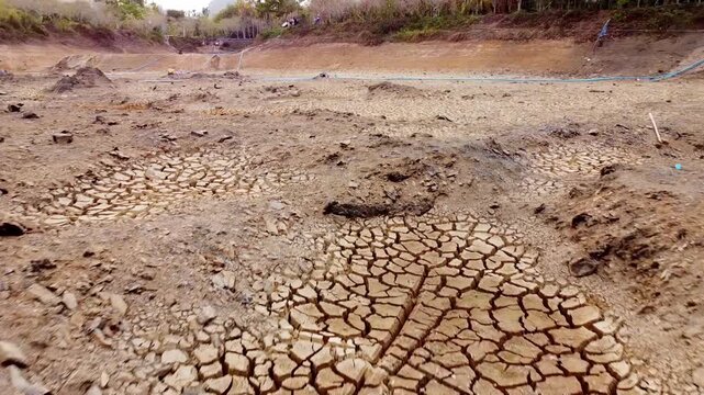 Drought and water crisis problems. A parched, cracked earth in a dry riverbed, signifying a severe drought and a desperate need for rain