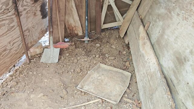 Worker throwing aluminum tray filled with soil for gardening or construction