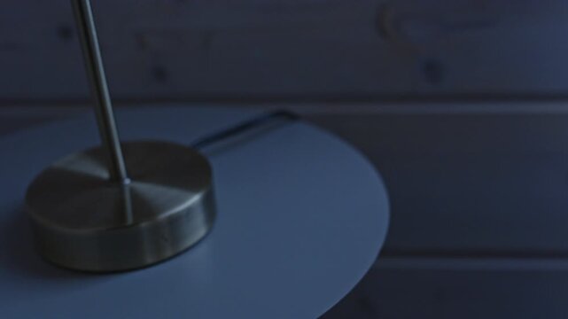 Close up of a bottle of pills on a bedroom nightstand being grabbed and placed back at night and being grabbed again