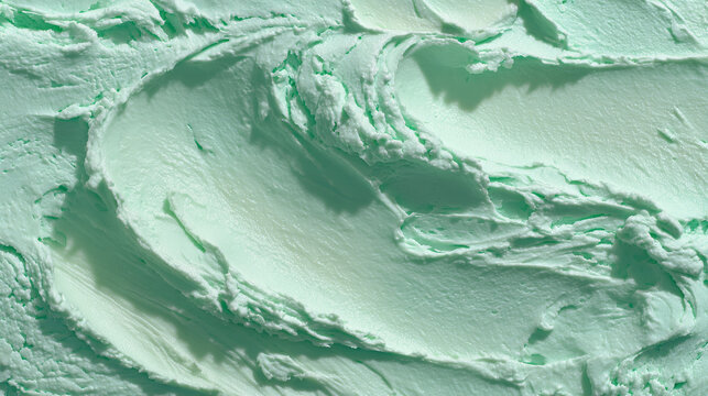 Close-up texture of light green mint ice cream with visible swirls and soft peaks.