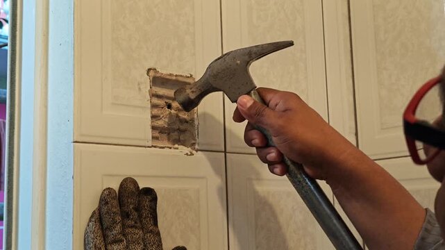 Young man inserting plastic wall anchor plug into bathroom wall