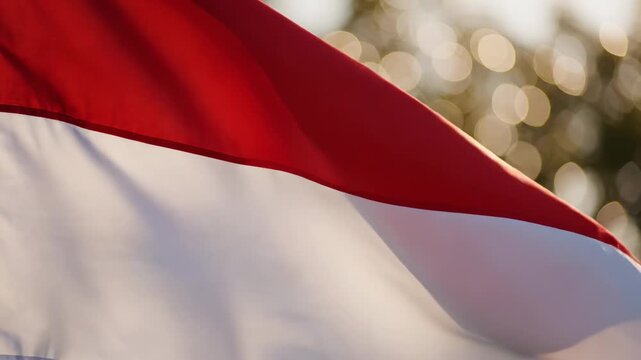 Close-up of a red and white flag waving gently in the wind, with soft bokeh lights in the background, representing patriotism and national pride