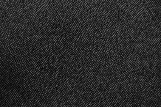Close up of dark black textured artificial leather surface elegant background with subtle details