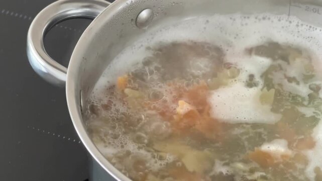 Boiling pot steams as vegetables simmer in broth