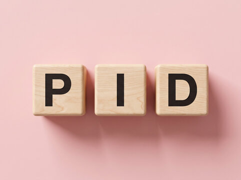 Premium natural wooden alphabet blocks spelling PID on soft pastel pink background representing pelvic inflammatory disease womens health awareness medical education concept