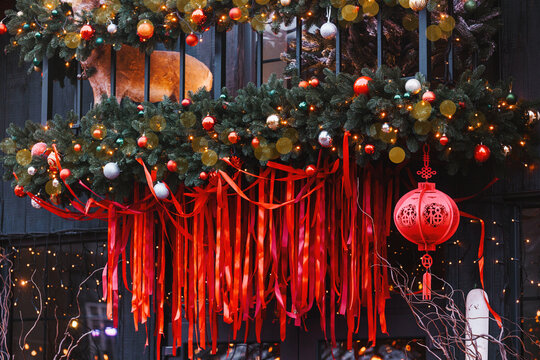 Festive evergreen garland adorned with colorful baubles red ribbons and a traditional lantern glowing brightly.