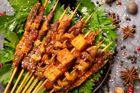 Grilled Meat and Vegetable Kebabs with Sesame Seeds and Fresh Herbs on Wooden Skewers