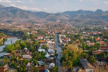 Fototapeta premium Morning panorama of Luang Prabang, Laos with temple roofs and mountain backdrop