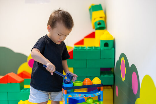 Little boy playing with colorful building blocks