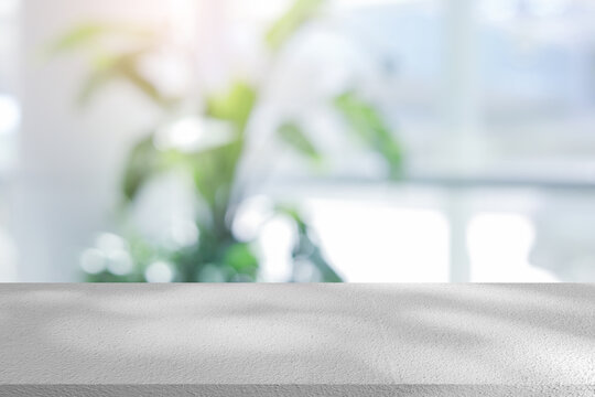 abstract blurred garden view form living room window with modern plain concrete table counter background for show , promote ,design banner ads on display concept