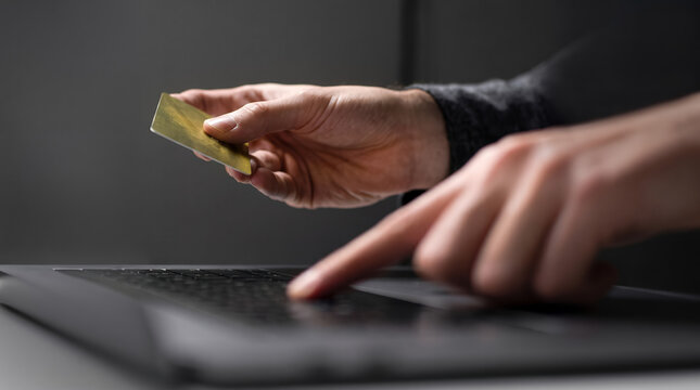 Young man making online payment with credit card on laptop