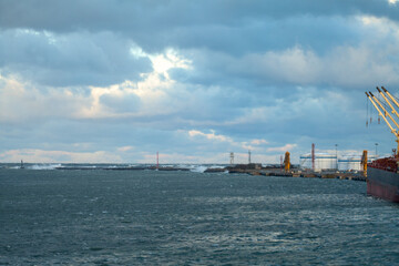 Naklejka premium Storm clouds over sea near industrial port