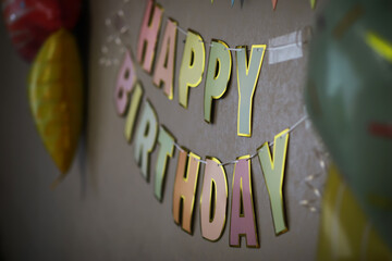 Fototapeta premium Colorful Happy Birthday Banner with Party Decorations on Wall