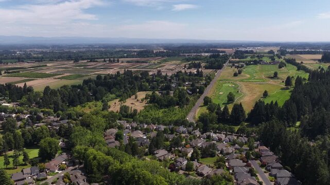 Aerial of suburbs with golf course and agricultural fields in Wilsonville Oregon featuring residential neighborhoods and rural fields