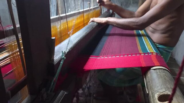 4k 120 fps slow motion video of a  handloom weaver in India working in his loom.	