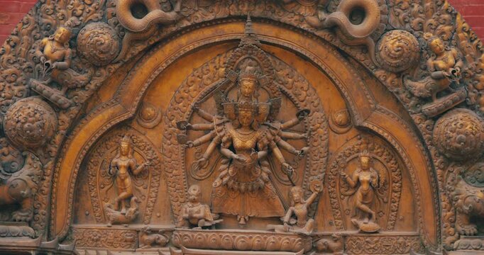 Bhaktapur Durbar Square Nepal, close up drone shot of highly detailed gilt bronze relief carvings depicting multi-armed deities on the famous Golden Gate structure in UNESCO heritage site.